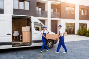 Two professional movers loading boxes during peak moving season.